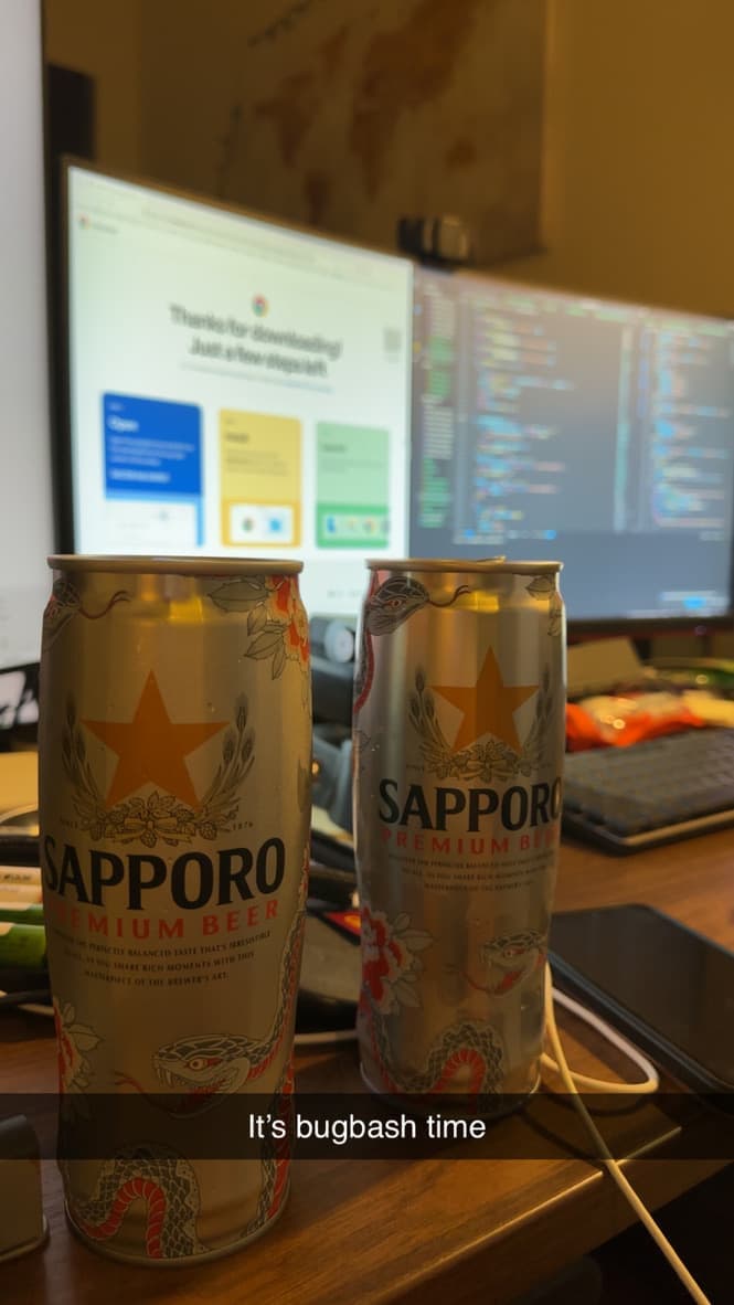 A photo of two beers on a desk with a code editor and chrome open in the background, with text that says 'It's bugbash time!'